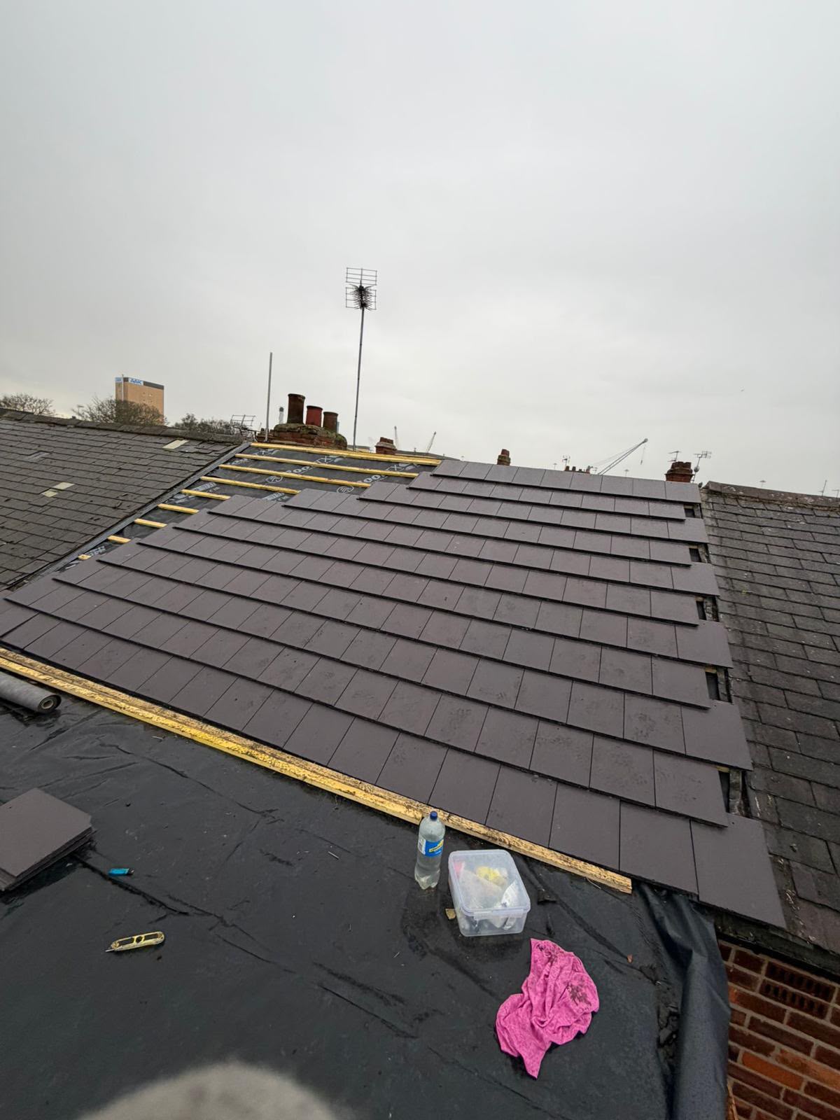 New roof tiling in progress over waterproof underlay and timber battens on a Yorkshire home