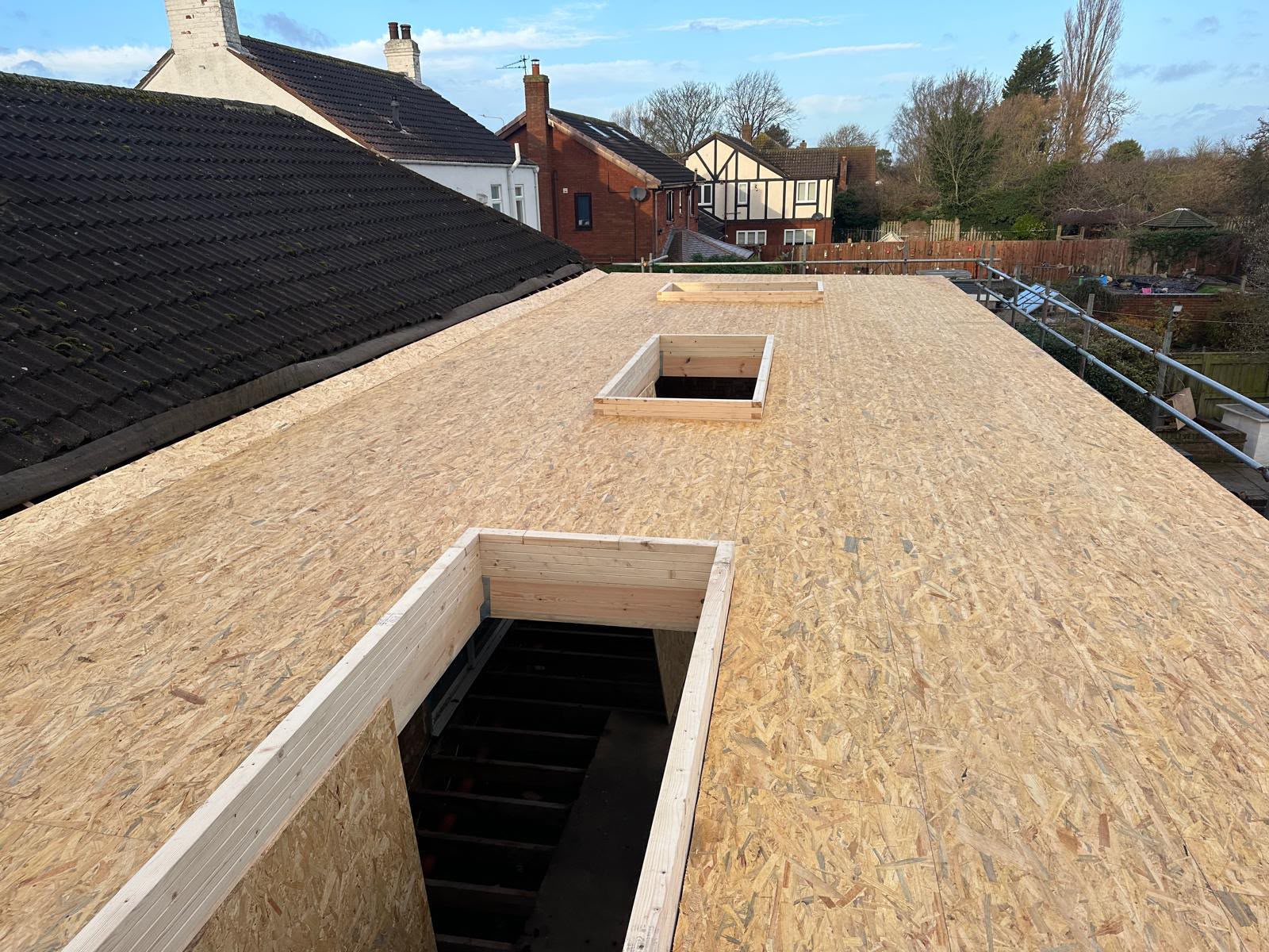 Flat roof OSB decking with three rooflight upstands framed and ready for EPDM