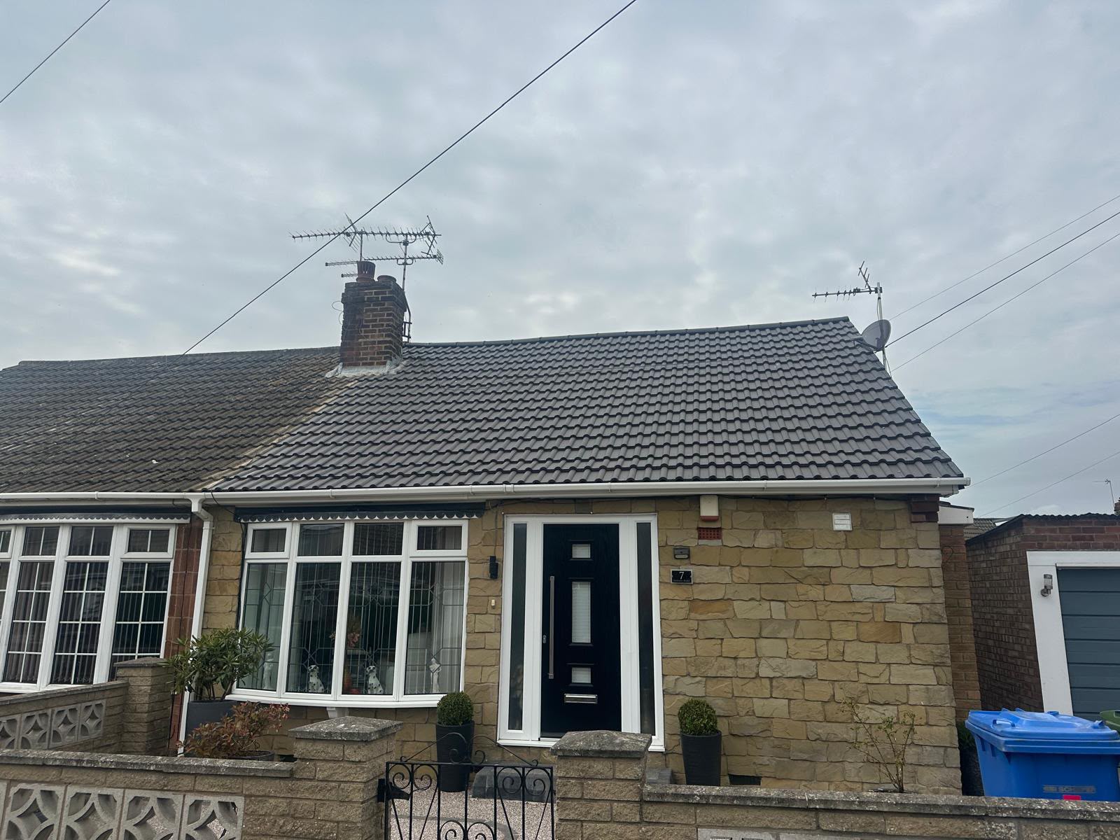 Newly re-roofed Yorkshire bungalow with dark grey interlocking tiles and a rebuilt brick chimney stack