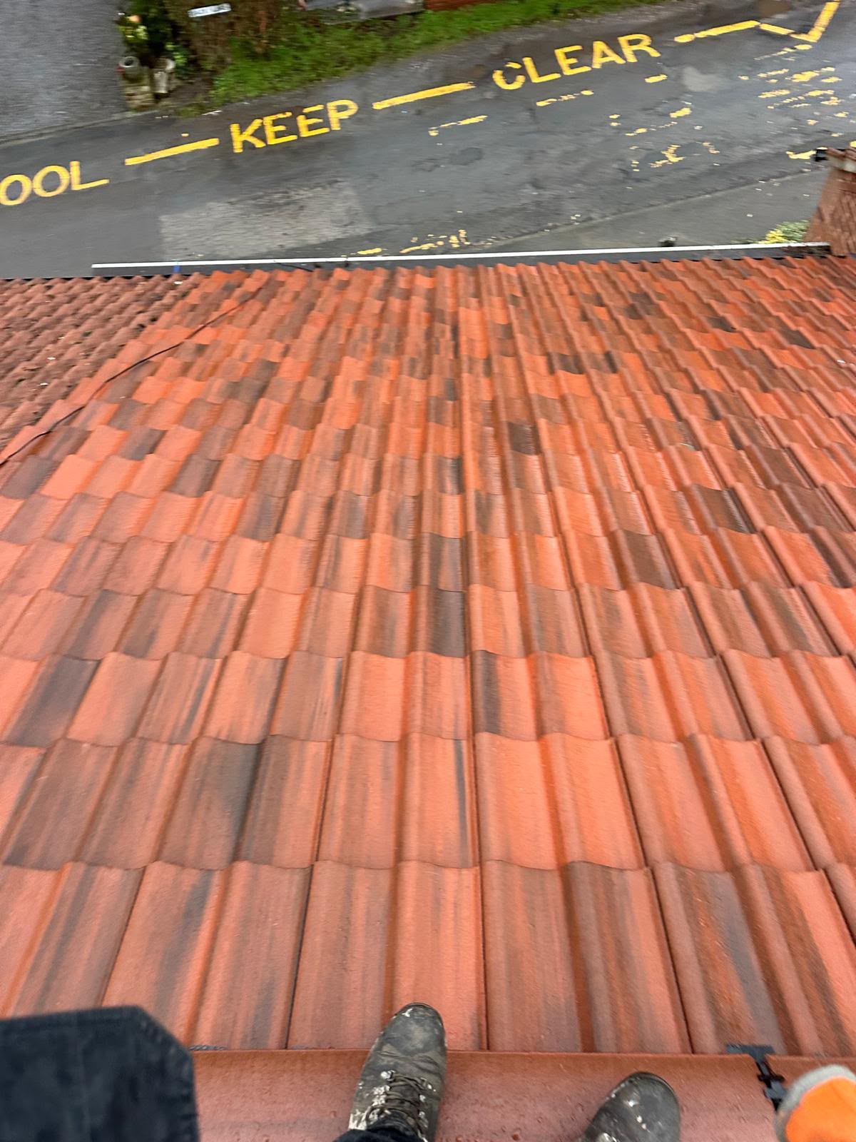 Completed red tiled roof with multi-tone Yorkshire clay pantiles above a residential street